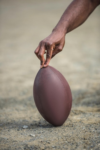 Closeup view of hand holding american football ball