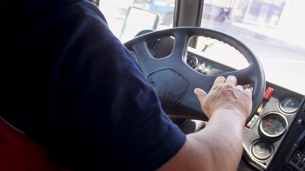 Closeup view of male bus driver in airport driving airport bus shuttle.