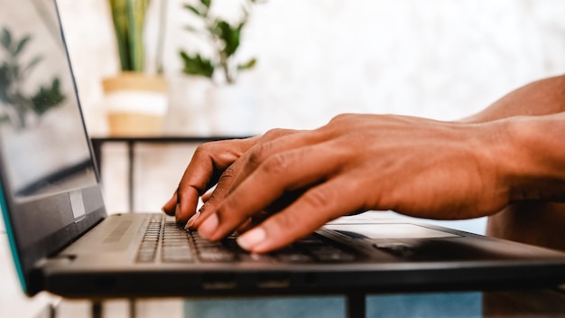 Closeup view of a man typing on laptop keyboard