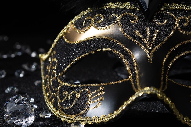 Closeup view of Masquerade gold mask with gemstones on black background