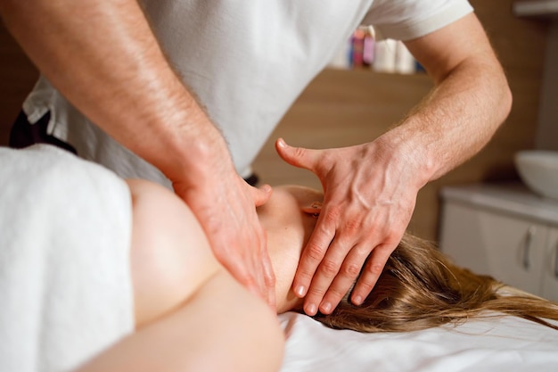 Closeup view of the masseur hands giving a neck and head massage