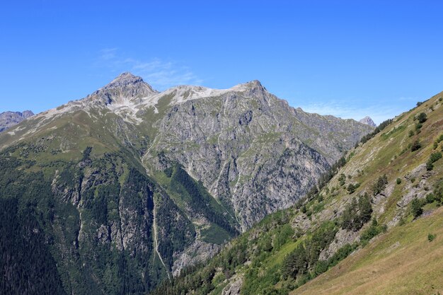 Closeup view mountains scenes in national park Dombai, Caucasus, Russia, Europe. Summer landscape, sunshine weather, dramatic blue sky and sunny day