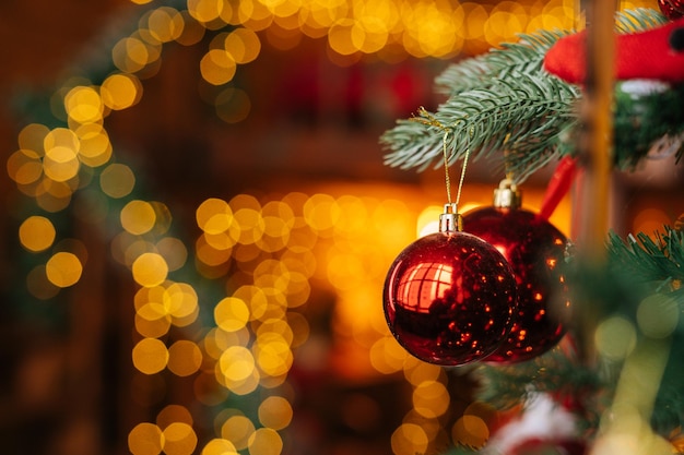 Closeup view of red beautiful ball on christmas tree background lot of blurry lights