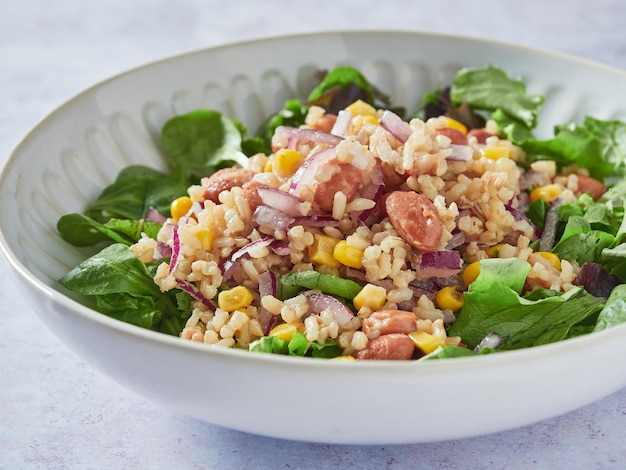 Closeup view of salad plate with rice beans corn red onion and lettuce greens