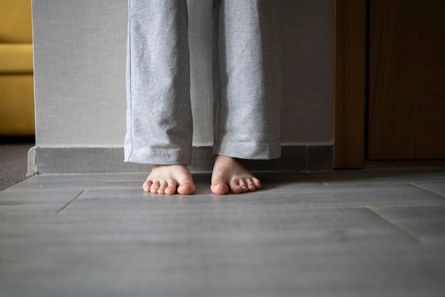 Photo a closeup view shows bare feet standing on a carpeted floor likely indicating the warmth from a heating system in a residential setting