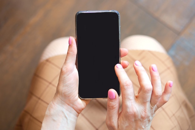 Closeup view of smartphone with black screen in woman hands copy space concept background high