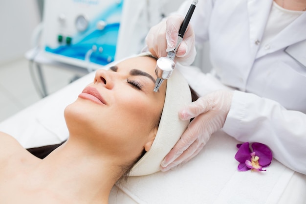 Closeup view of a womans head receiving diamond microdermabrasion treatment skin care and profession...