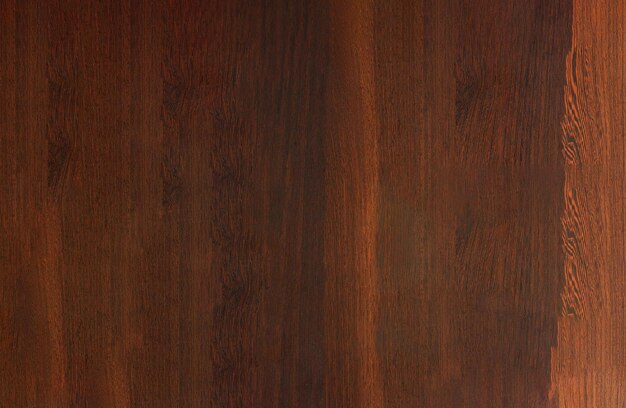 A closeup view of a wooden surface with a dark brown finish