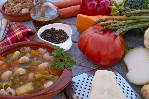 Closeup view of a wooden table with a fresh ready to eat homemade vegetable soup