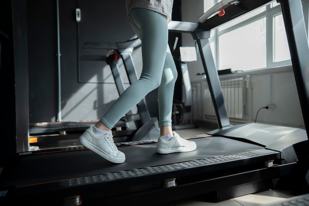 CloseUp View Of A Young Womans Feet Running On A Treadmill In A Gym