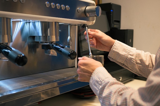 Closeup of a waiter at a coffee machine