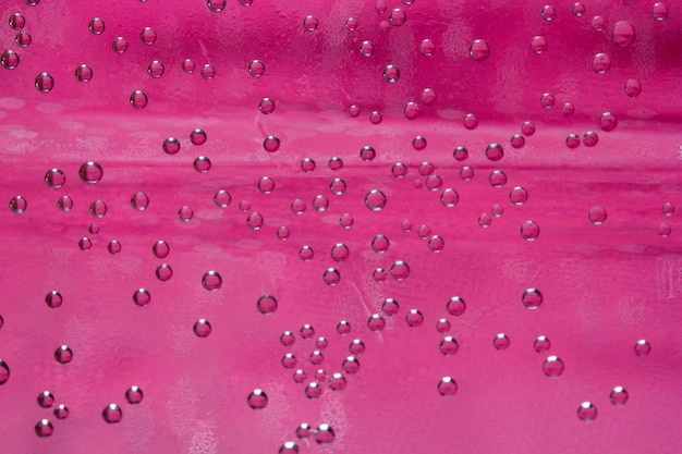 Closeup water drops pink background