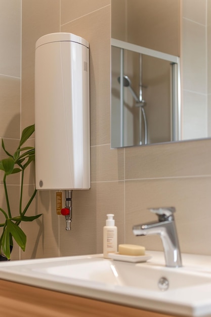 Closeup water heater in a modern bathroom with mirror and washbasin sink