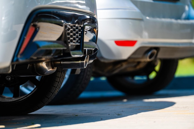 Closeup of the wheels and bumpers of a car parked in the yard of a residential house lower section