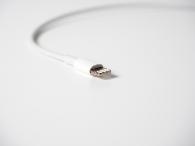 Closeup of a white lightning cable isolated on a white background Cable for charging gadgets and transmitting information