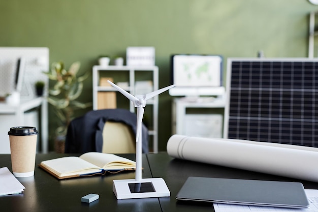 Closeup of windmill model for alternative energy standing on table of engineer at office