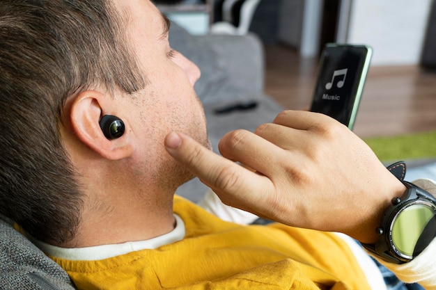 Closeup of wireless earphone in human ear insert earphone into the ear listening to music with headphones