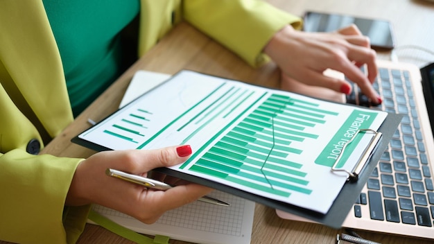 Closeup of woman accountant typing statistics data of financial report woman working on laptop