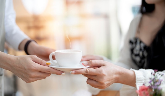 Closeup of woman barista serving cup of coffee to customer Job and occupation