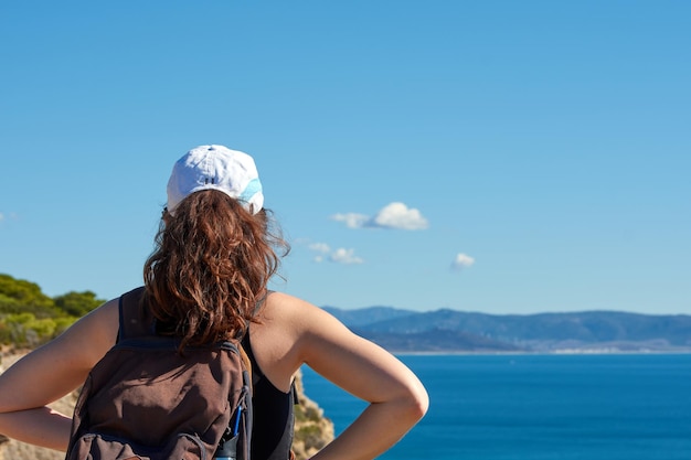 A closeup of a woman from behind looking at the sea