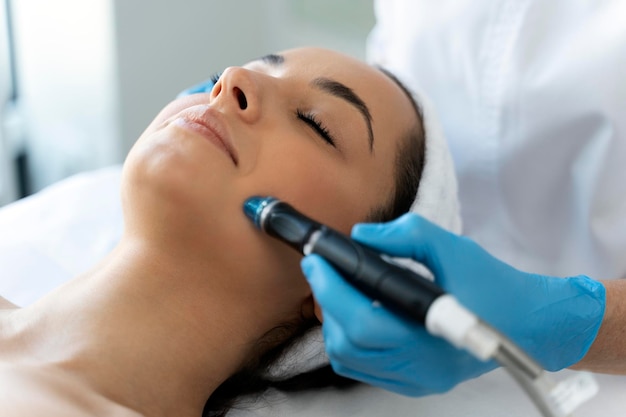 Closeup of woman getting facial hydro microdermabrasion peeling treatment