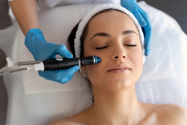 Closeup of woman getting facial hydro microdermabrasion peeling treatment