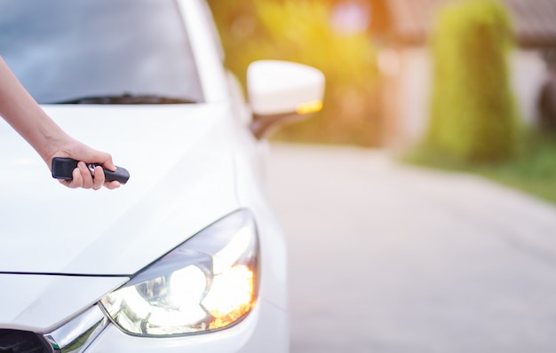 Closeup woman hand holding the remote control car alarm systems