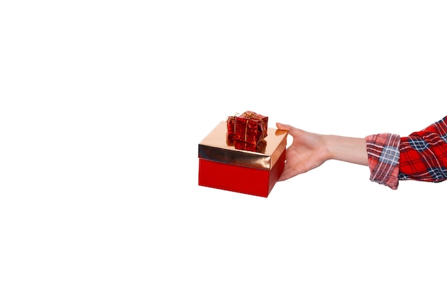 Closeup of a woman hand holding a small gold and red gift box over white  background