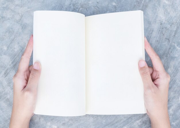 Closeup woman hand read a book on concrete desk