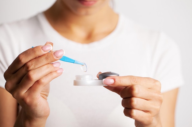 Closeup Of Woman Hands Holding White Eyelense Container.