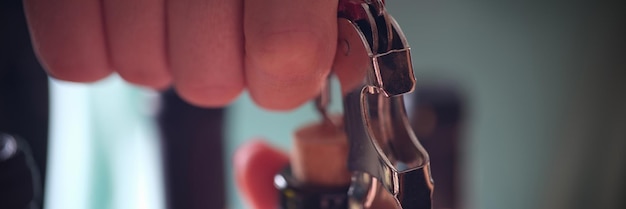 Closeup of woman opening bottle of wine with corkscrew holiday and party concept