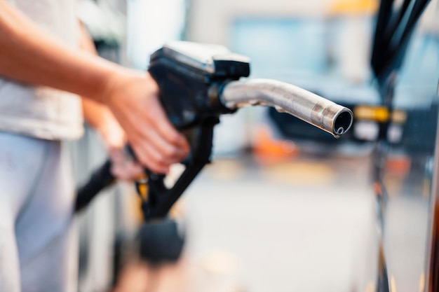 Closeup of woman pumping gasoline fuel in car at gas station Petrol or gasoline being pumped into a motor Transport concept