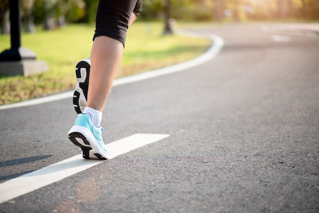 Closeup woman running towards on the road side. Step, run exercise concept.