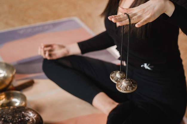 Closeup of a woman's hand holding Tibetan bells for sound therapy Tibetan cymbals