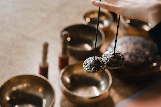 Closeup of a woman's hand holding Tibetan bells for sound therapy Tibetan cymbals