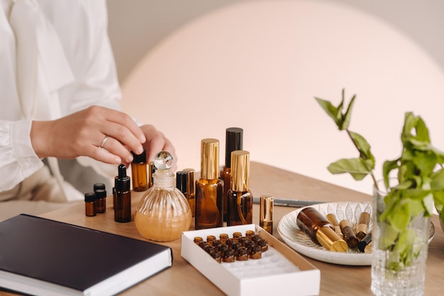 Closeup of a Woman's hands applying essential oil on her wrist indoors