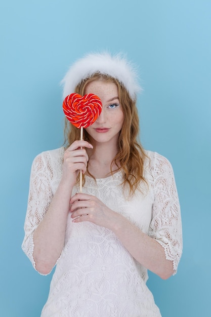 Closeup of woman's holding a heart lolipop in front of her