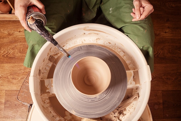 Closeup of a woman sculpts clay vase