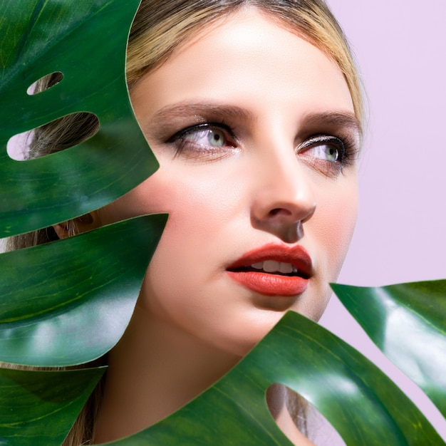 Closeup woman with alluring perfect clean skin holding green leave