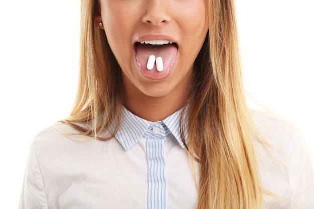 Closeup of woman with tablet in her mouth