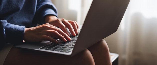 Photo closeup of a woman working and typing on laptop computer keyboard