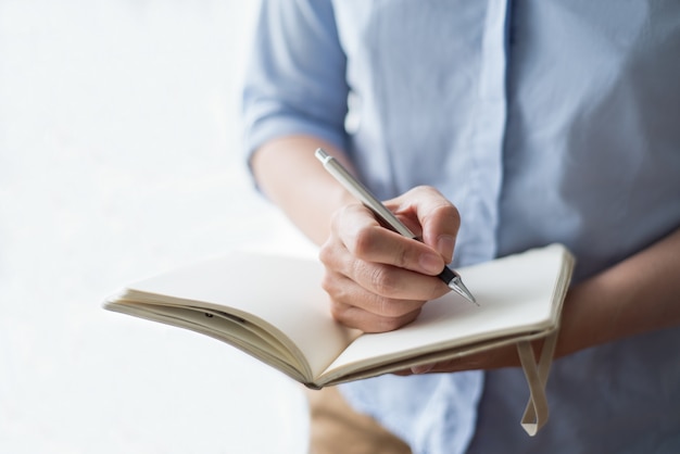 Closeup of Woman Writing in Notebook