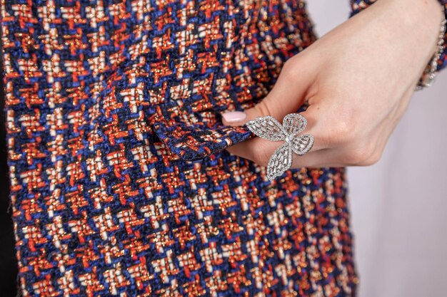 Closeup of woman39s hand on tweed jacket holding flower