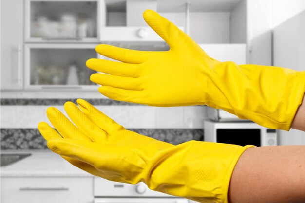 Closeup of women's hands wearing yellow rubber gloves