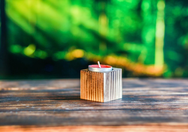 Closeup of a wooden candlestick against a blurred green background