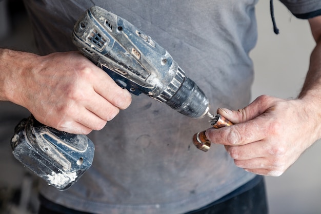 Closeup worker plumber master cleaning copper pipes with professional brush.