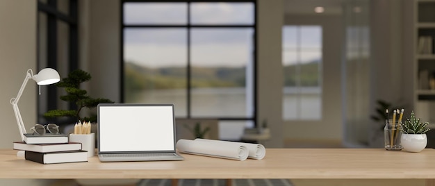 Closeup workspace with laptop mockup roll of blueprints and decor in modern room