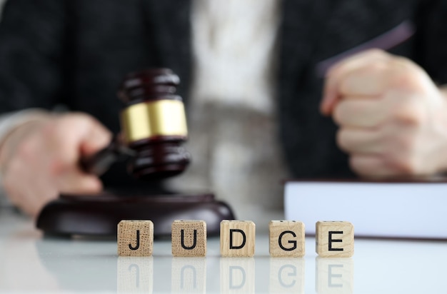 Closeup of world judge collected of wooden cubes letters justice and law male judge in