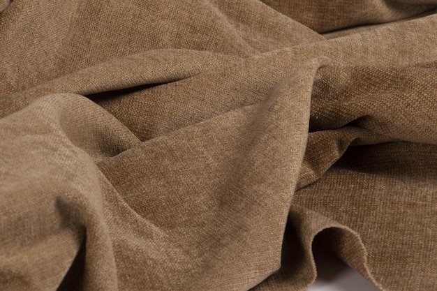 Photo closeup of a wrinkled natural bro chenille fabric texture