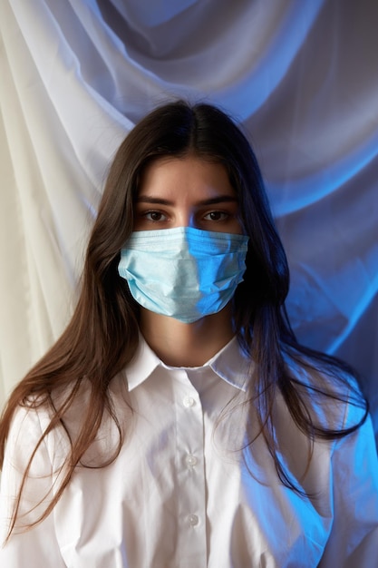 Closeup of a young caucasian woman with a surgical mask on her face against covid19